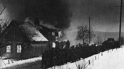 German infantry, led by a Panzer, pause by a burning village in Norway before resuming their advance in March 1940.