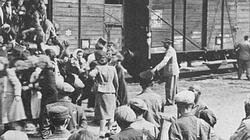 Loading Jewish deportees on cattle car from the Lodz ghetto. The men with military caps are Jewish police.